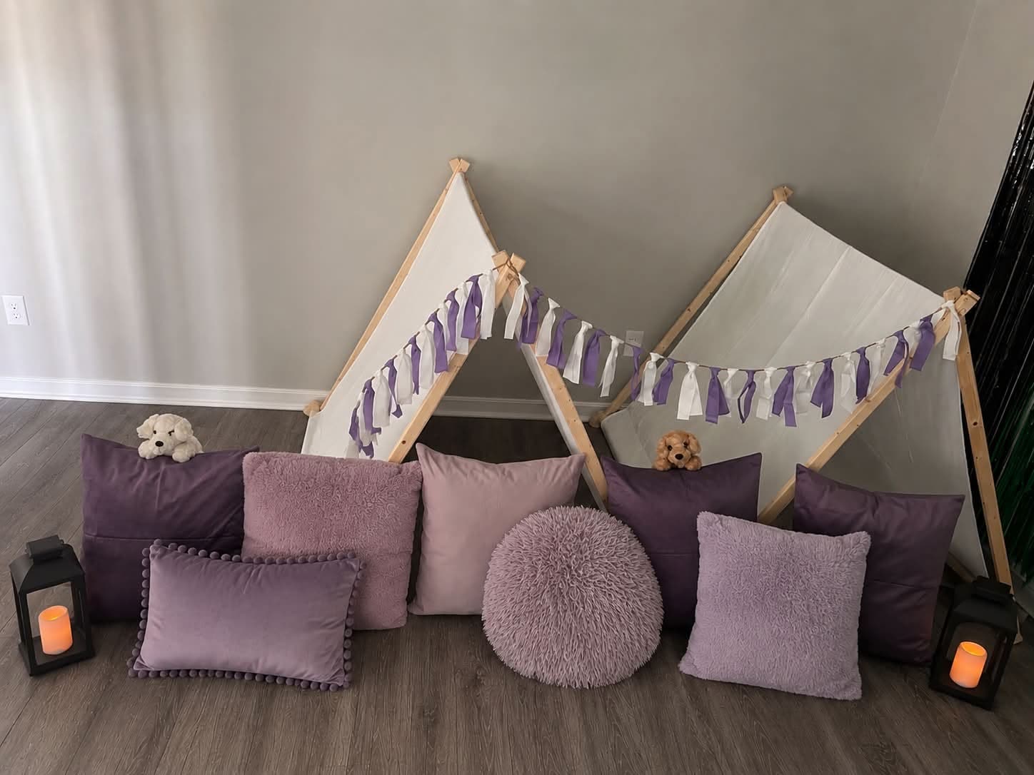 Two teepee tents styled with layered lavender cushions as a photo backdrop