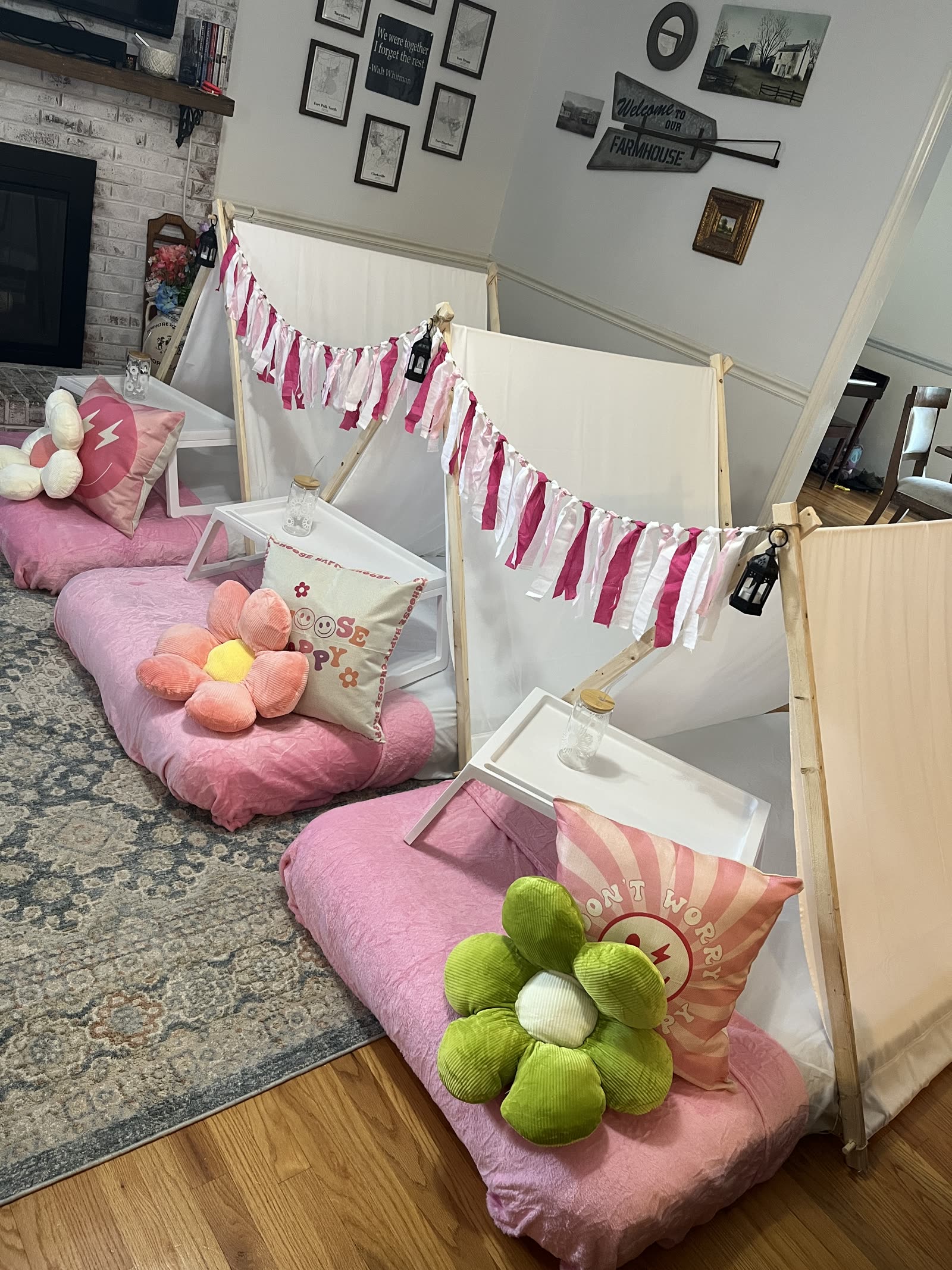 Close view of pink teepee bedding with flower pillows, bed trays and a black lantern