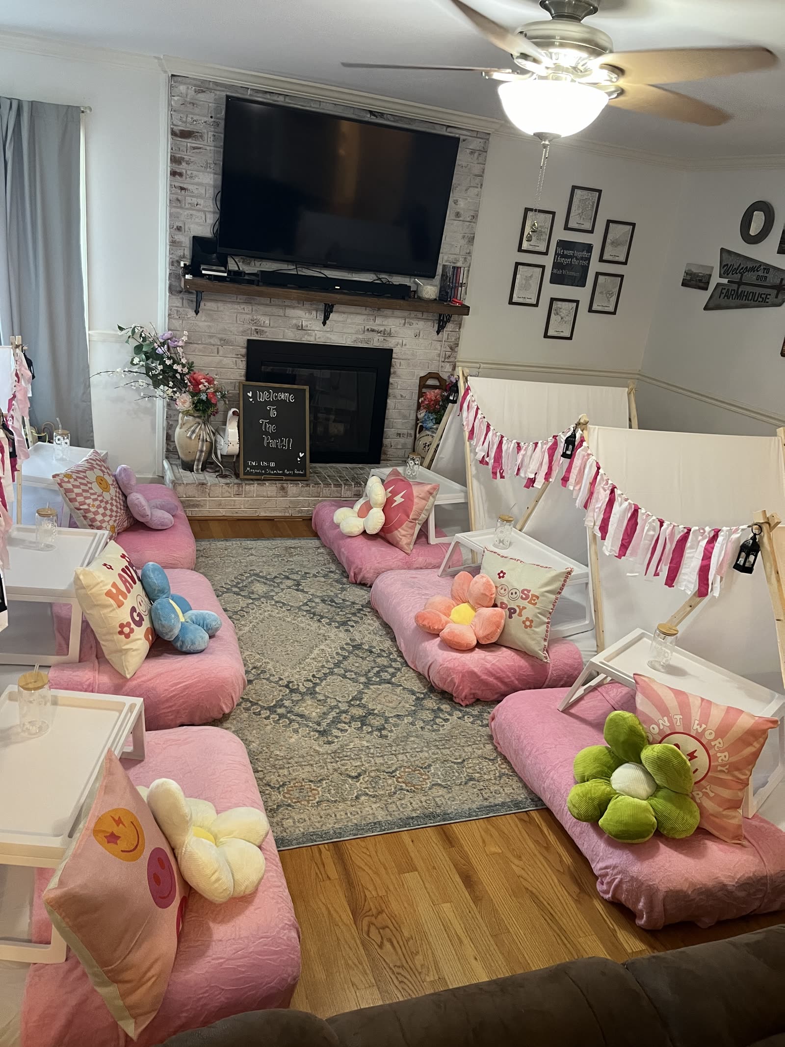 Wide view of a six-tent pink sleepover filling a family living room